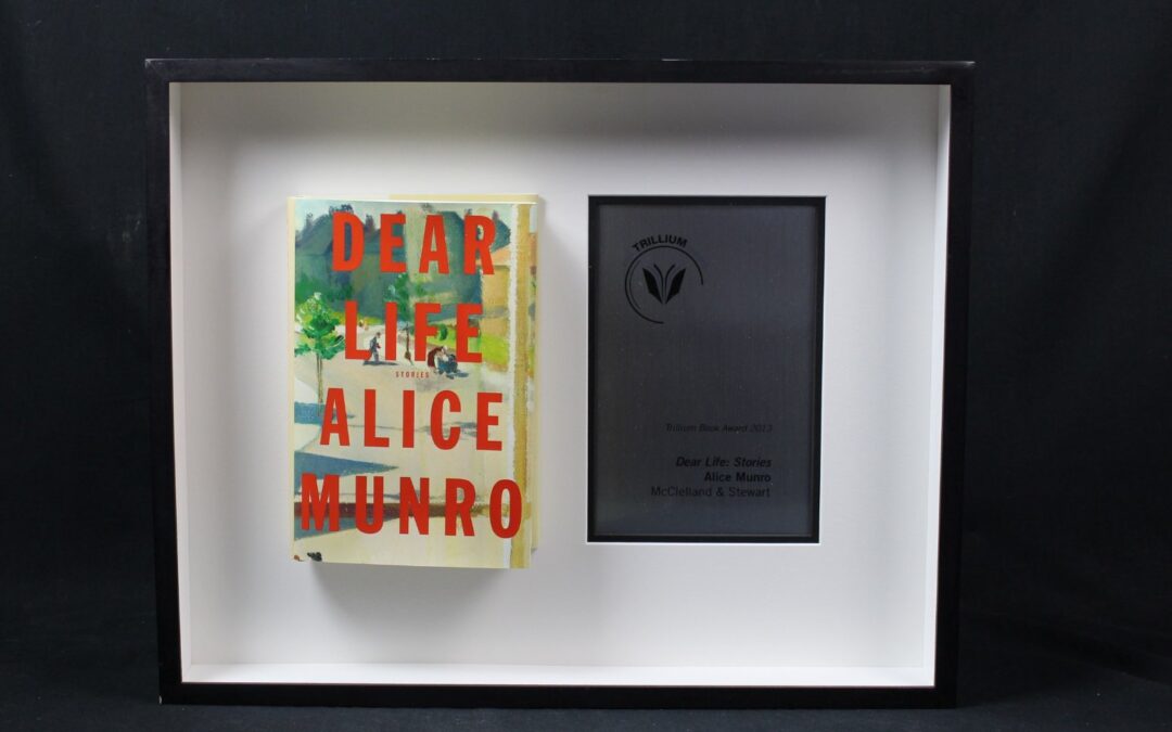Hardcover book (left) and award (right) in frame. The book is Alice Munro's "Dear Life." The Trillium Award is Ontario's highest prize for literature.
